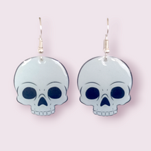 Load image into Gallery viewer, How cute are these little skulls? These stunning earrings are designed and made in-house and are also available in grey. Material: shrink film, resin, nickel free hooks. Please note as these are all handmade, minor differences may occur from piece to piece.  All shrink film products can take about a week to send out as they are currently made to order

