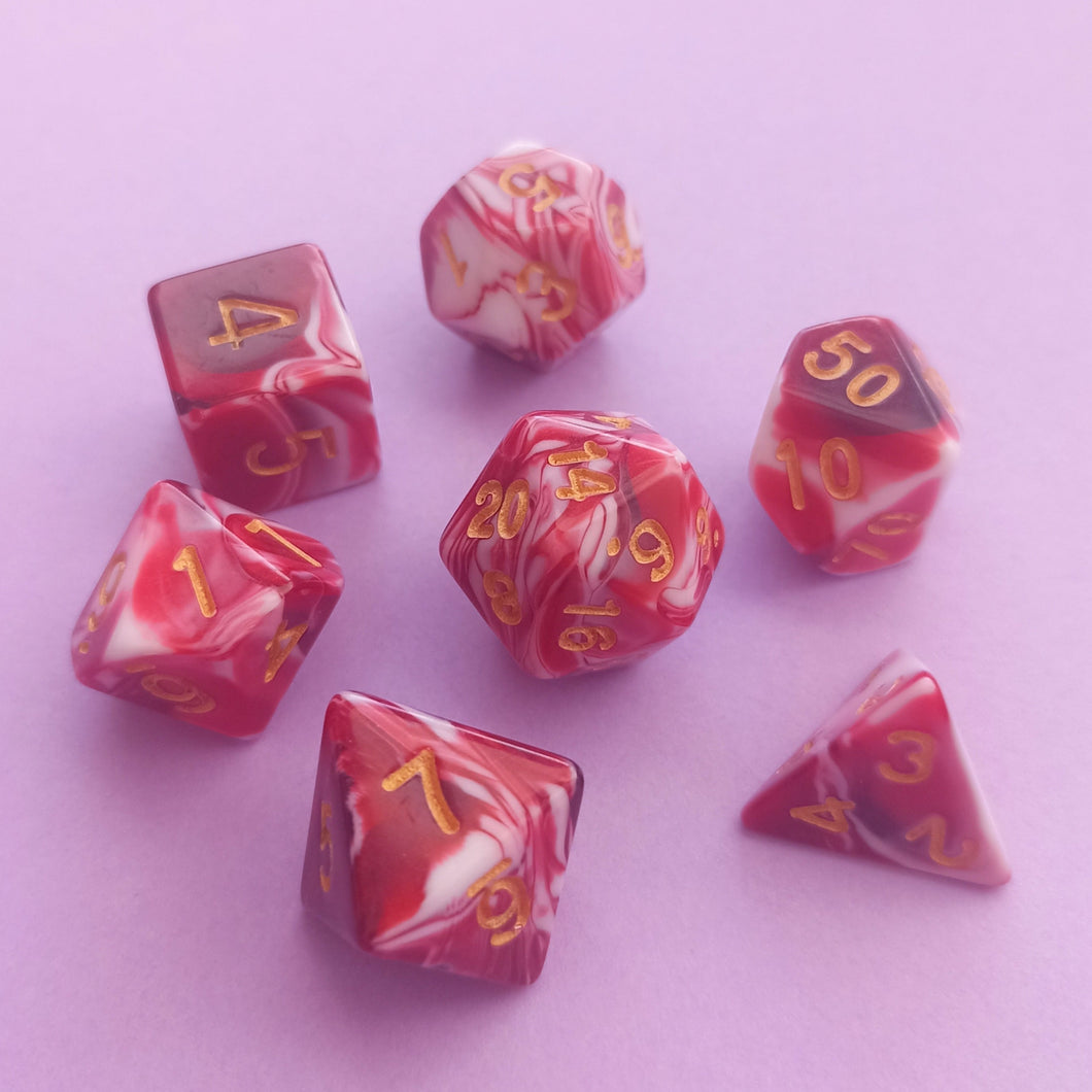 This beautiful yet somewhat gorgy dice set resembles spilled blood mixing with liquids.

We're trying out something new and these stunning limited addition resin DnD dice are just a little teaser before we hopefully launching our own custom dice range later this year. All of our dice will be limited and mostly will not be restocked as each batch comes out differently. Please note each set will be different to the next depending on the pour.