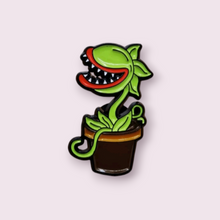 Load image into Gallery viewer, This stunning pin is inspired by the charismatic plant, Audrey 2, coming from the captivating musical Little Shop of Horrors. This pin is sure to delight my fellow theatre nerds. Size roughly 3.1x1.8cm. Material: enamel
